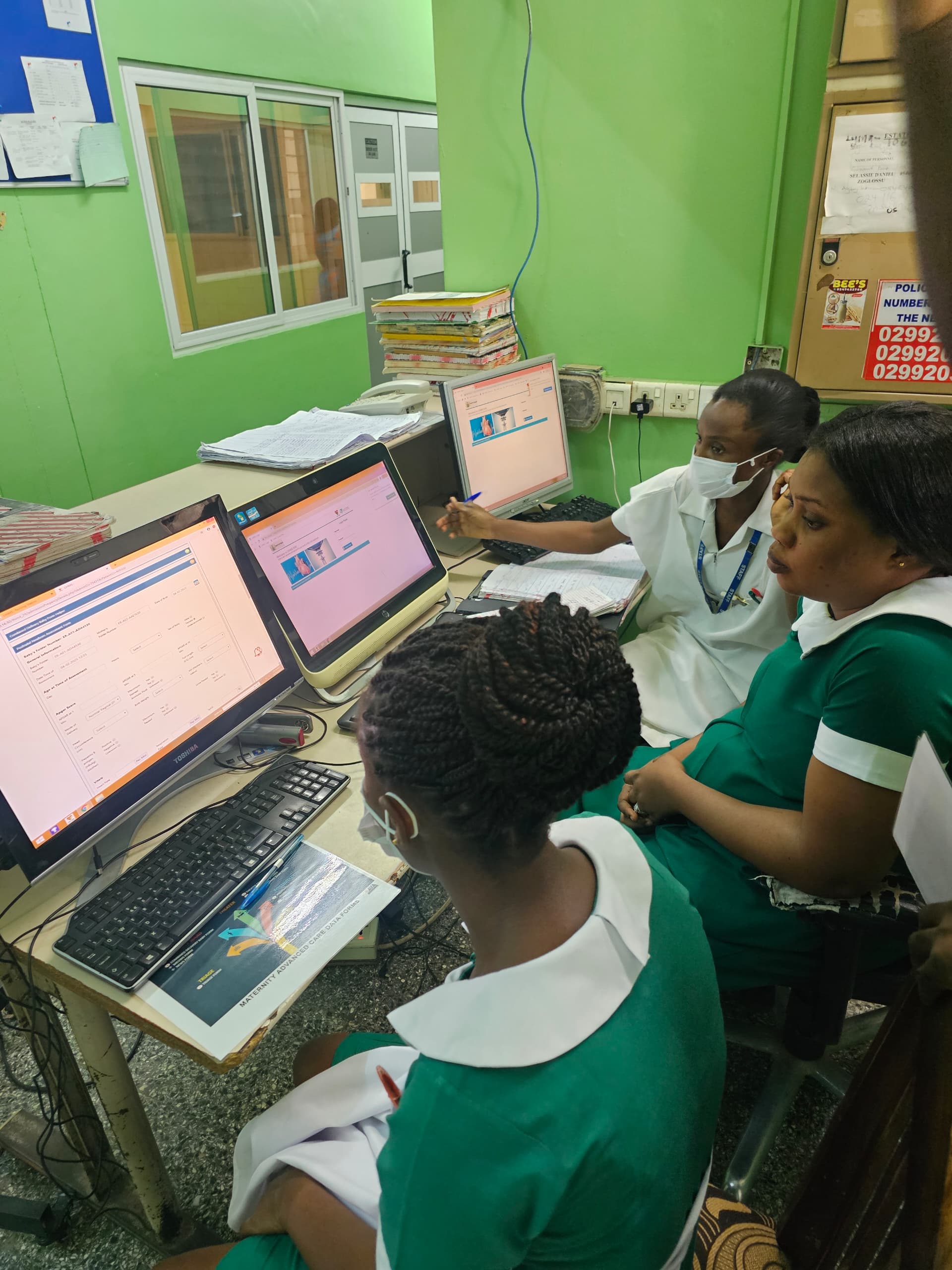 Nurses entering data at computers during a MEBCI facility visit